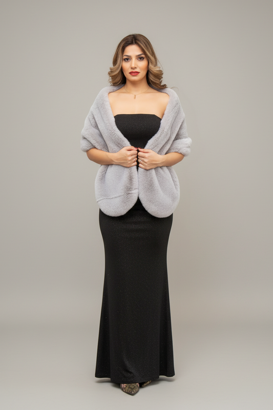 Woman in a black dress with a gray shawl standing in front of a mirror.