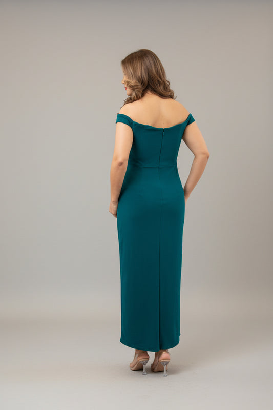 Woman in a teal evening gown standing in front of a mirror.