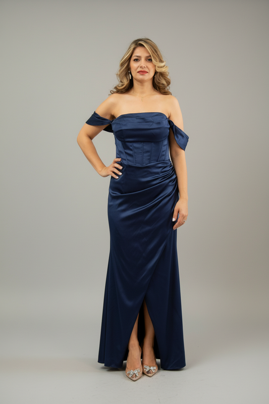 Woman wearing a navy off-shoulder gown against a gray background