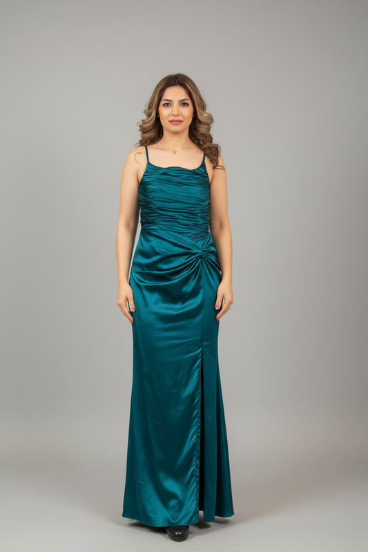 Woman in a teal evening gown standing in front of a mirror.