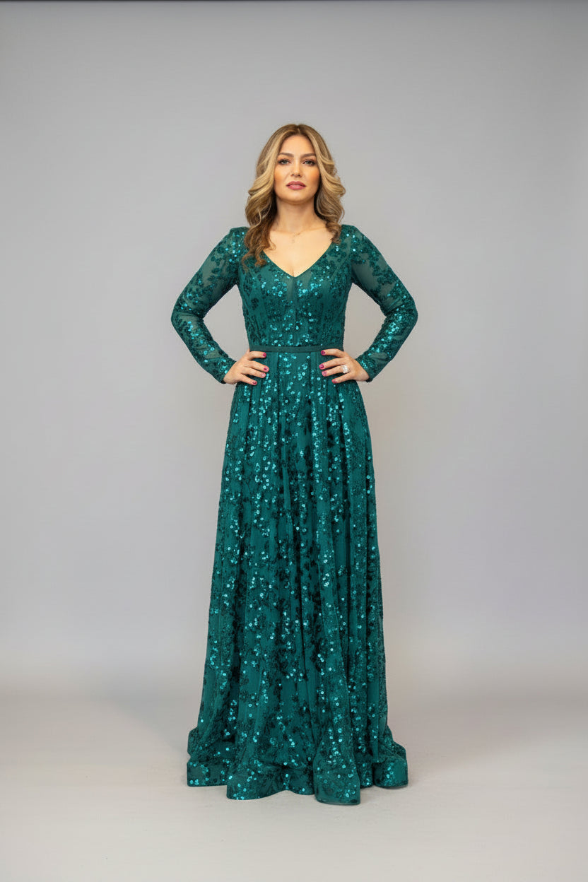 Woman in a green sequin dress standing in room.
