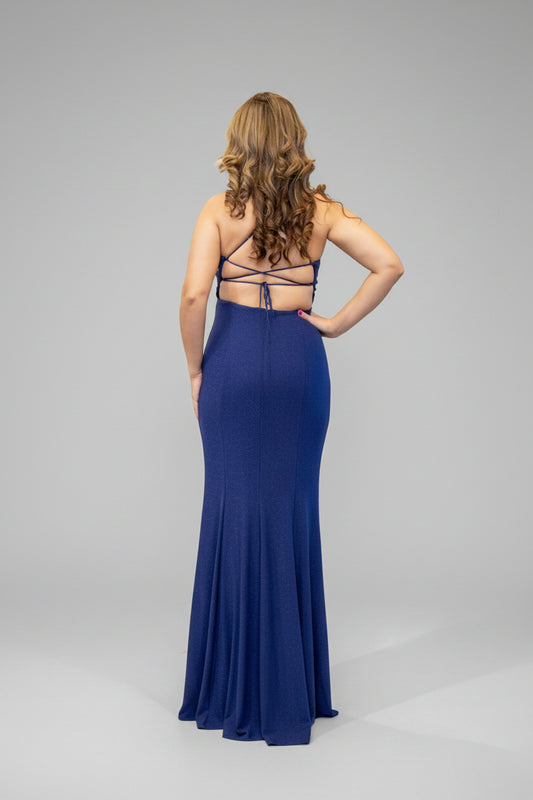 Woman in a blue evening gown standing in front of a mirror.