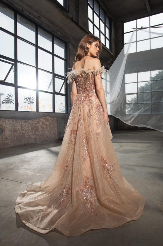 Woman in a beige off-shoulder gown with floral details in an industrial setting.