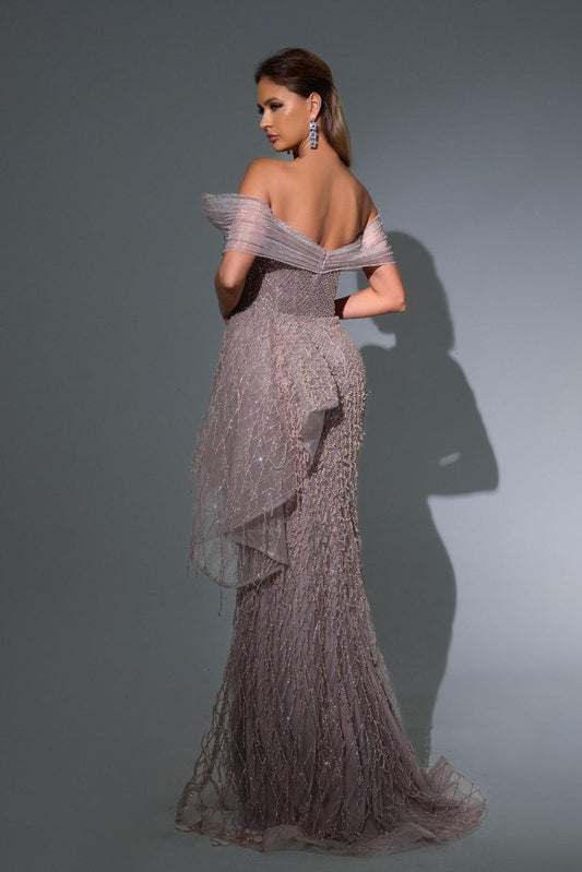 Woman wearing a sparkling evening gown against a gray background