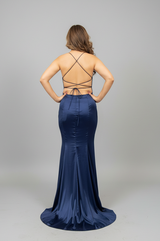 Woman in a blue evening gown standing in front of a mirror.