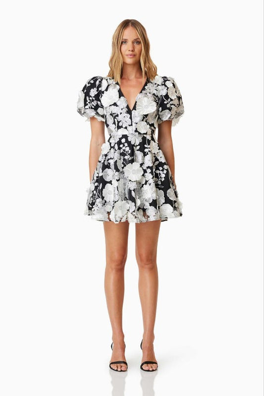 Woman wearing a black and white floral dress on a white background
