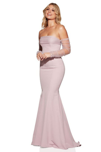 Woman wearing a pink strapless gown with sheer sleeves on a white background
