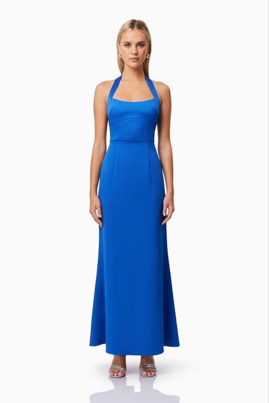 Woman wearing a blue halter neck dress on a white background