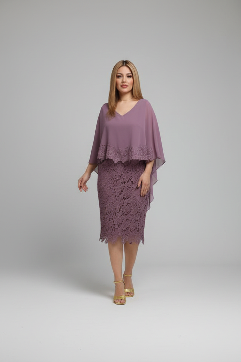 A woman modeling a mauve purple two-piece outfit consisting of a V-neck sheer cape top and a matching lace pencil skirt, paired with gold platform sandals, against a neutral gray studio background.