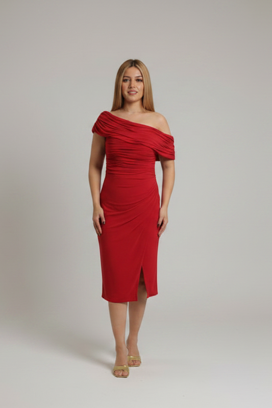 A woman modeling a teal off-the-shoulder midi dress with ruched detailing and a front slit, standing against a neutral light gray studio background.