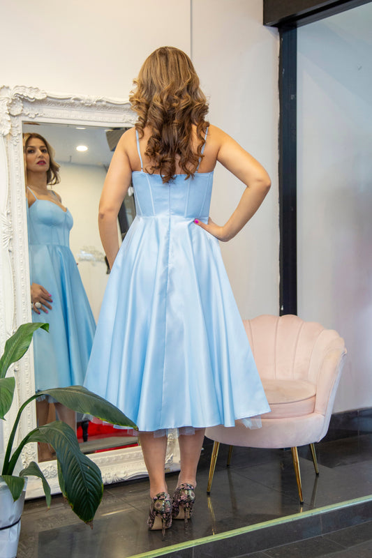 Woman in a light blue dress standing 