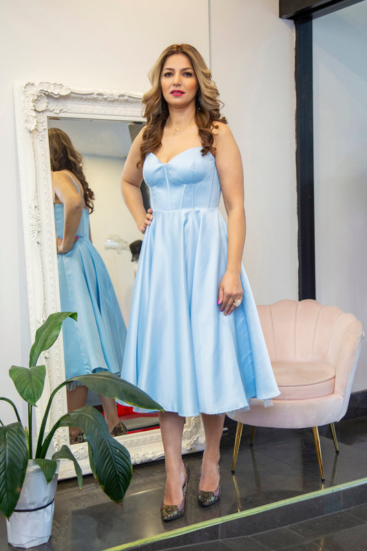 Woman in a light blue dress standing 