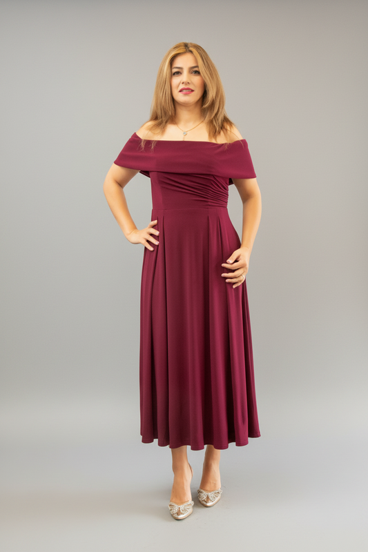 Woman in a burgundy off-shoulder dress standing in front of a mirror.