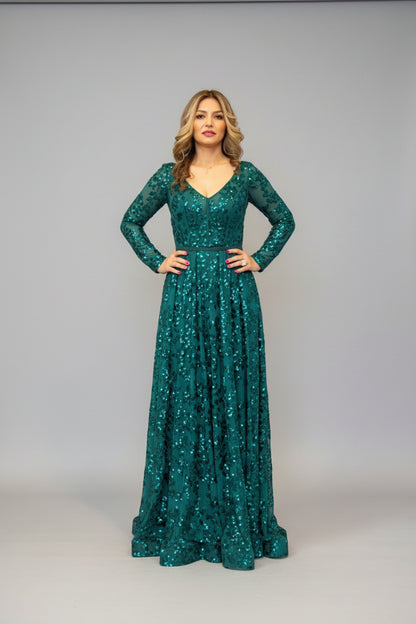 Woman in a green sequin dress standing in room.