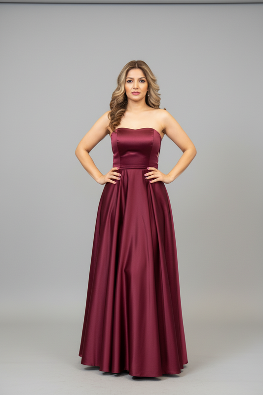 Woman wearing a burgundy strapless gown on a gray background