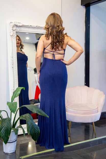 Woman in a blue evening gown standing in front of a mirror.