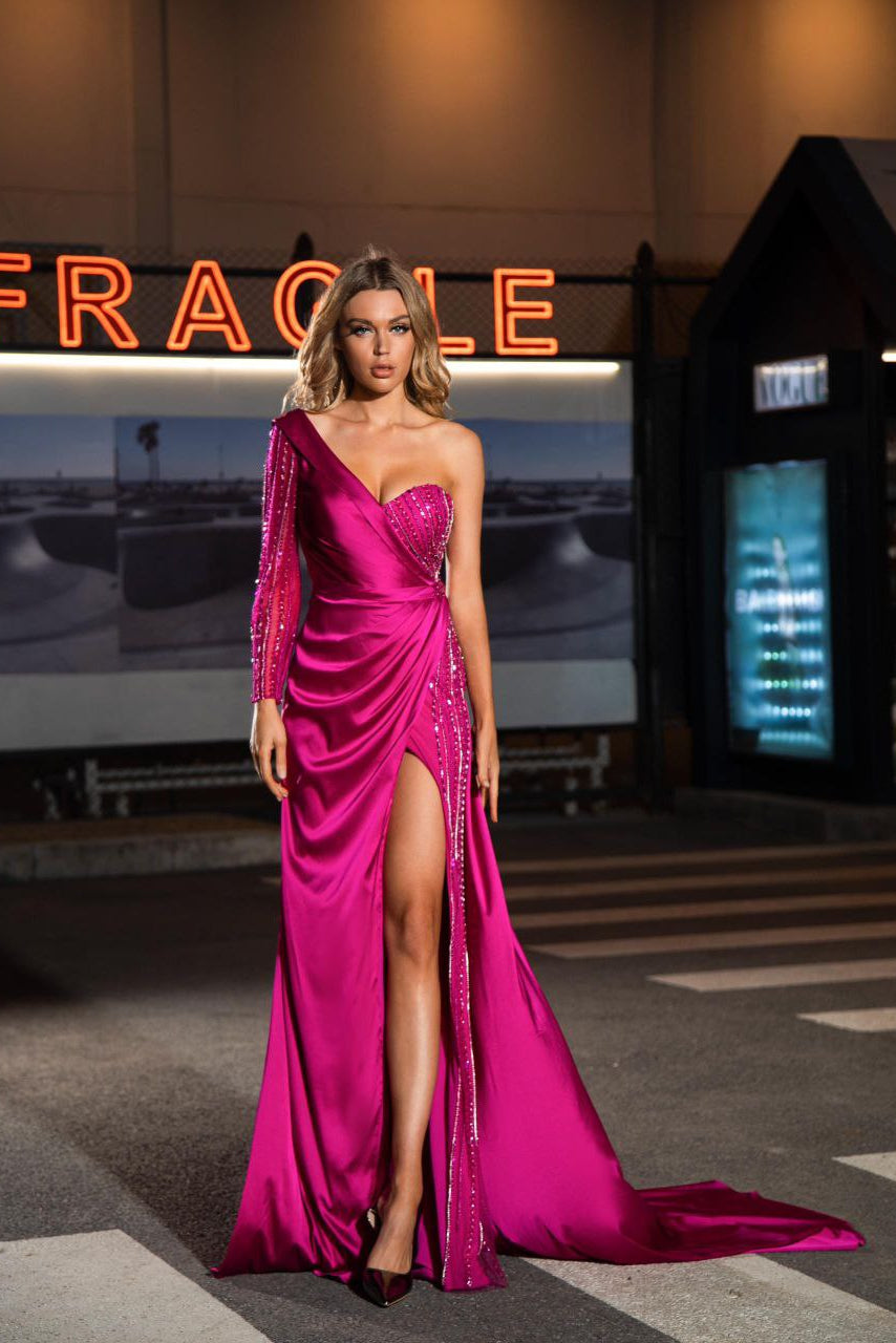 Woman in a pink evening gown standing on a street with a 'Fragile' sign in the background.