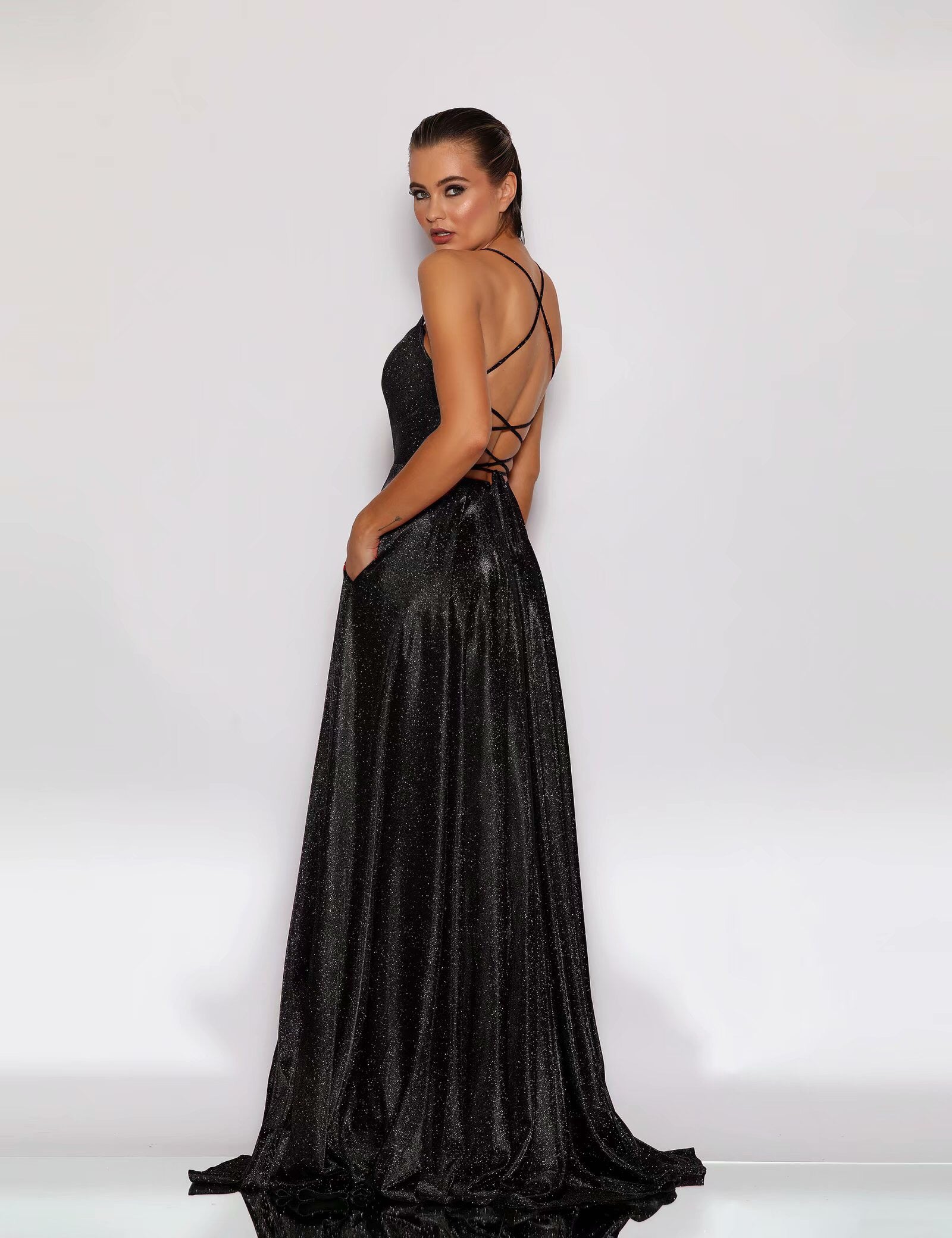 Woman wearing a black evening gown with a white background