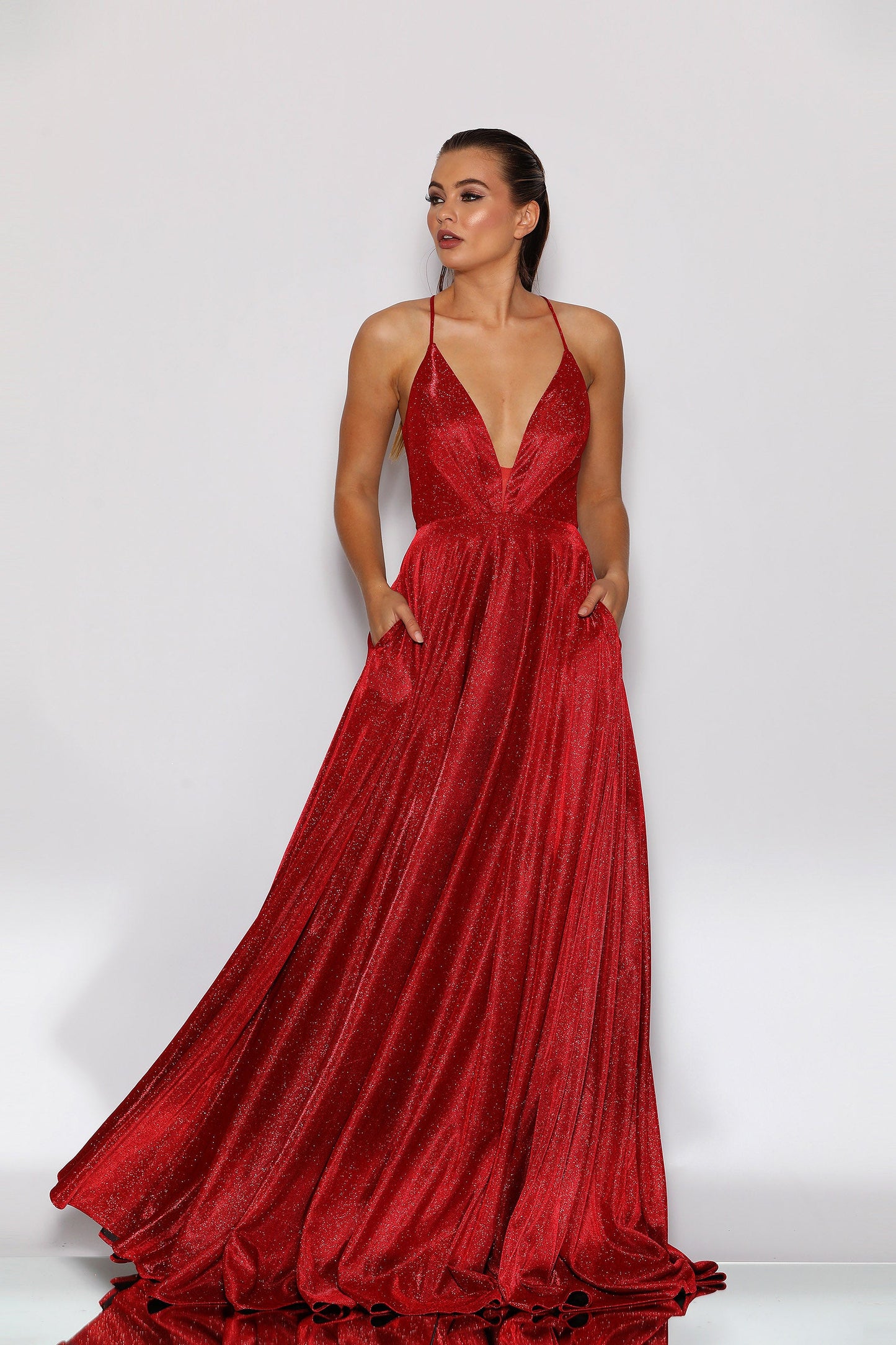 Woman wearing a red evening gown against a white background