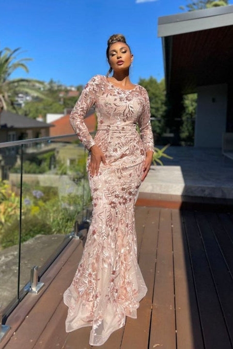 Woman in a floral dress standing on a wooden deck with a scenic background