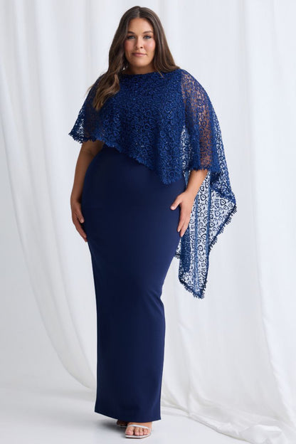 Woman wearing a navy blue dress with lace sleeves against a white background