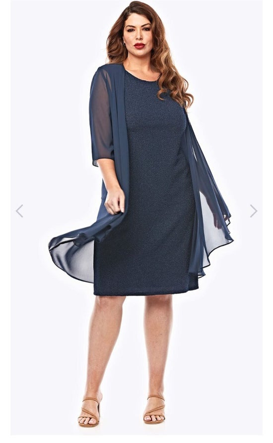 Woman wearing a navy dress with a matching jacket on a white background