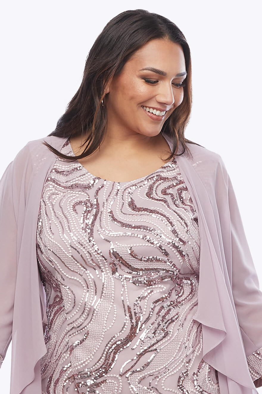 Woman wearing a sequined dress with a matching jacket on a white background