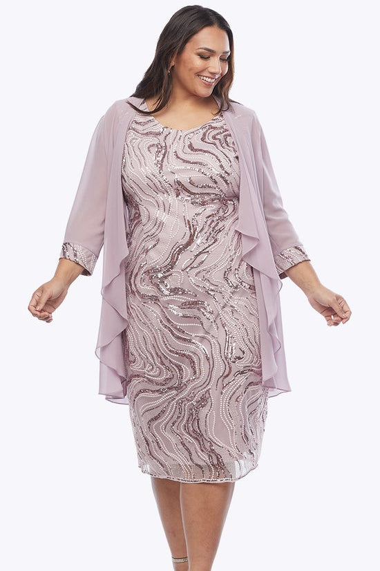 Woman wearing a patterned dress with a matching jacket on a white background