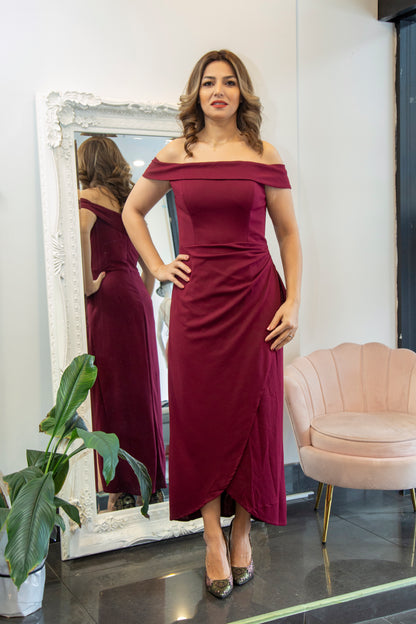 Woman in a burgundy off-shoulder dress standing in front of a mirror.