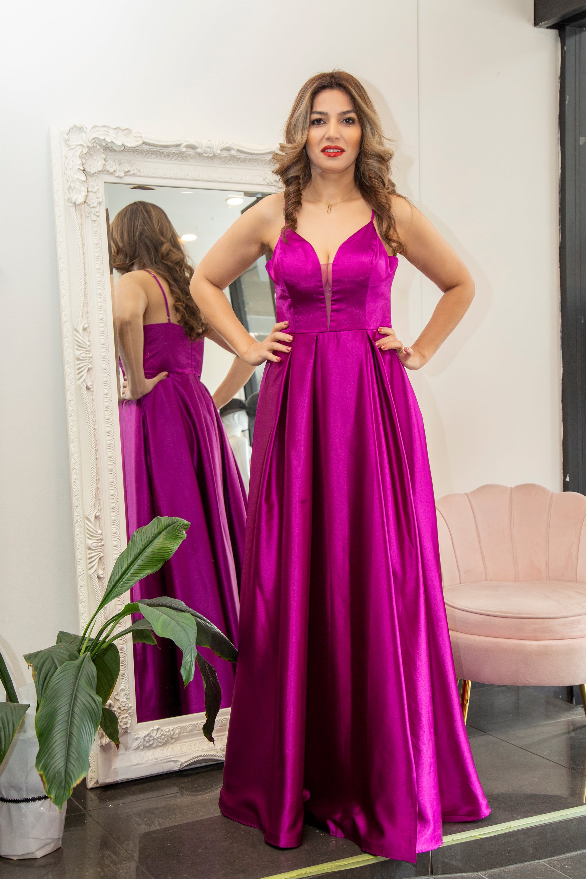 Woman in a purple evening gown standing in front of a mirror.