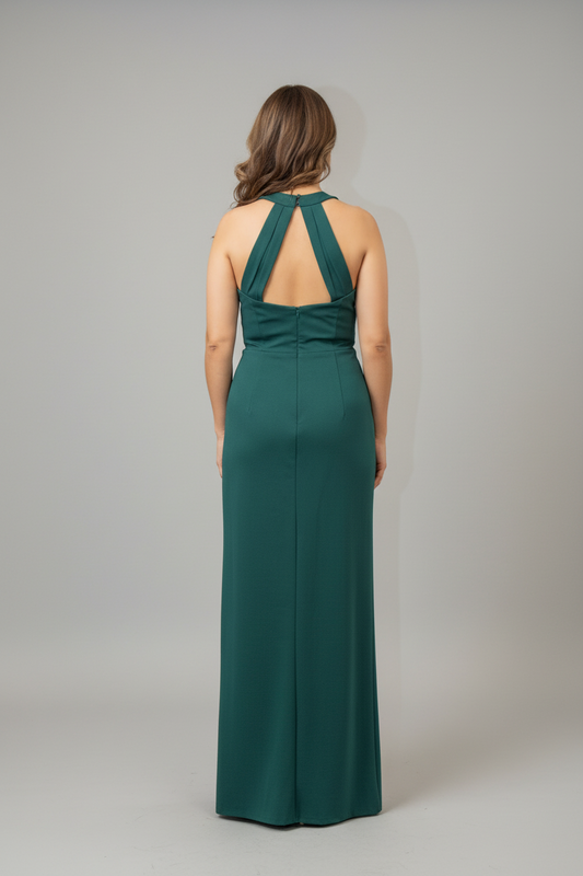 Woman in a green evening gown standing in front of a mirror.