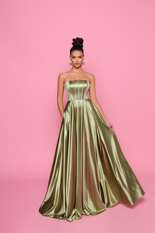 Woman wearing a strapless green gown against a pink background