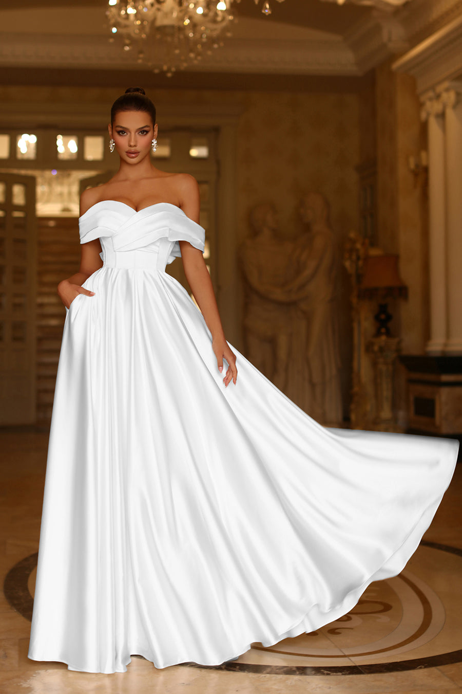 Woman wearing a white off-shoulder gown in an elegant indoor setting