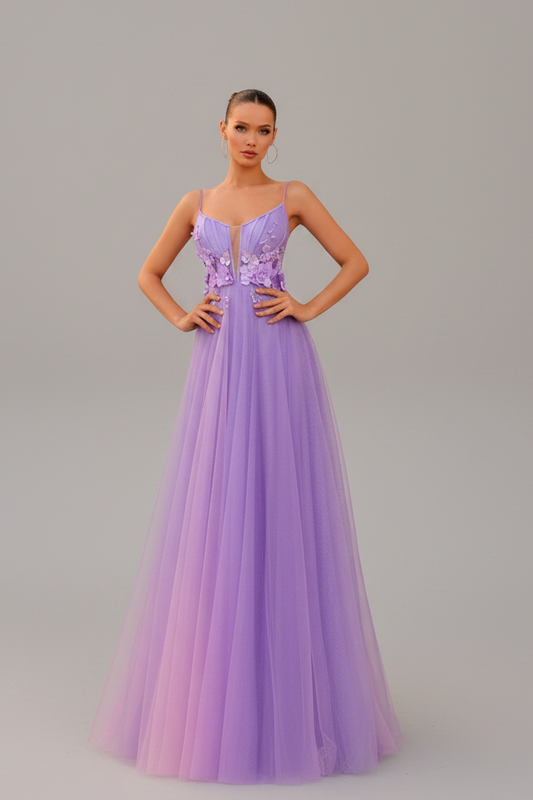Woman in a strapless, floor-length dress with floral details standing on steps.