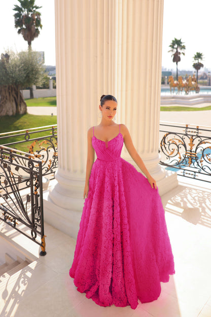Woman in a pink lace dress standing on a balcony with a scenic background