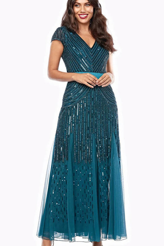 Woman wearing a teal beaded evening gown on a white background