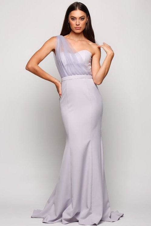 Woman wearing a light purple evening gown against a plain background