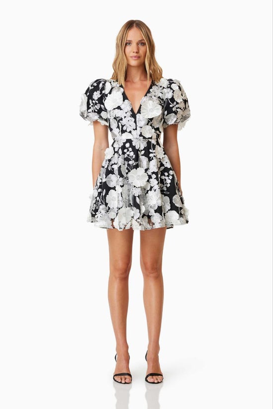 Woman wearing a black and white floral dress on a white background
