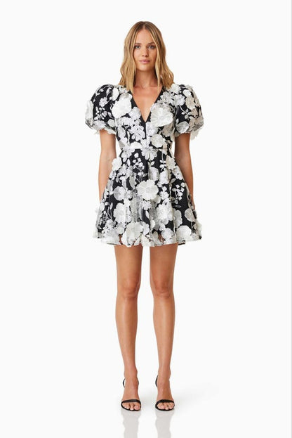 Woman wearing a black and white floral dress on a white background