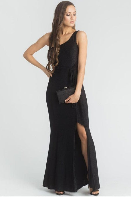 Woman wearing a black one-shoulder dress with a slit on a white background