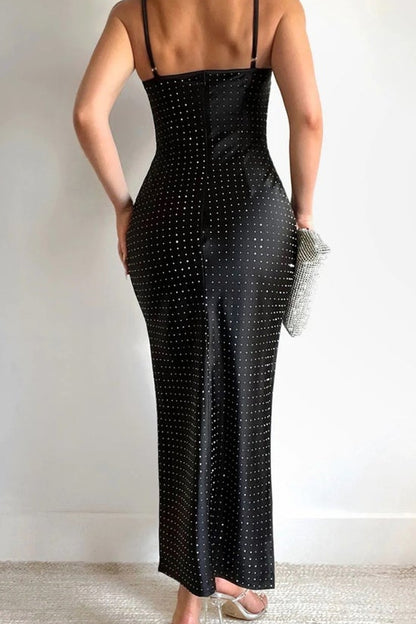 Woman wearing a black dress with thin straps against a white background